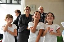 Drei Mädchen der Grundschule im Vordergrund, Staasministerin Barbara Klepsch und Ausländerbeuaftragter Geert Mackenroth im Hintergrund